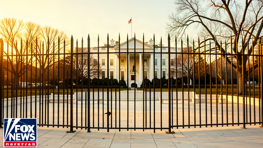 A tall dark metal fence with pointed tops being erected around a white stone plaza, the White House visible behind it